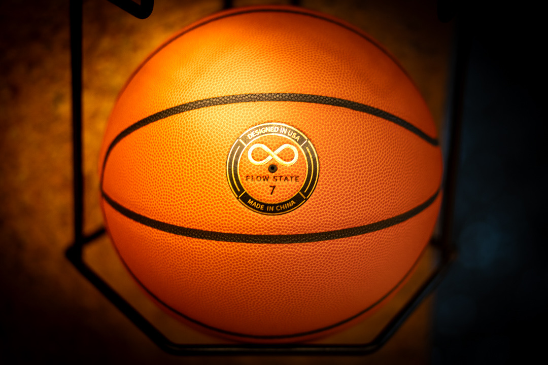 Flow State custom basketball with in-mold branding on a club ball rack
